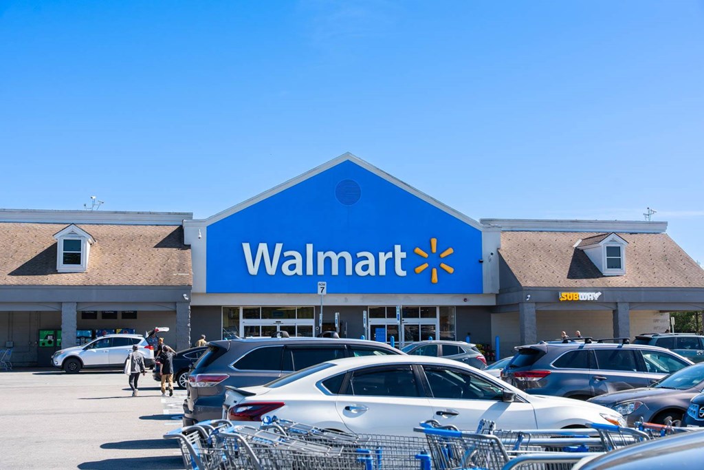 A Walmart store with cars parked in front.