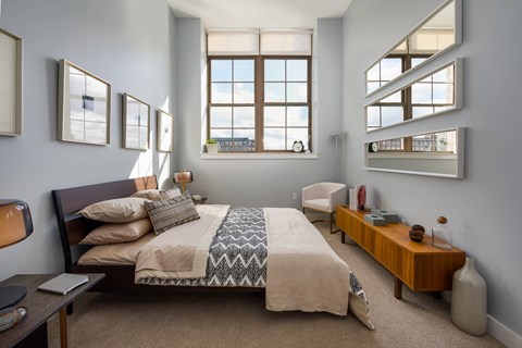 a bedroom with a bed and some windows