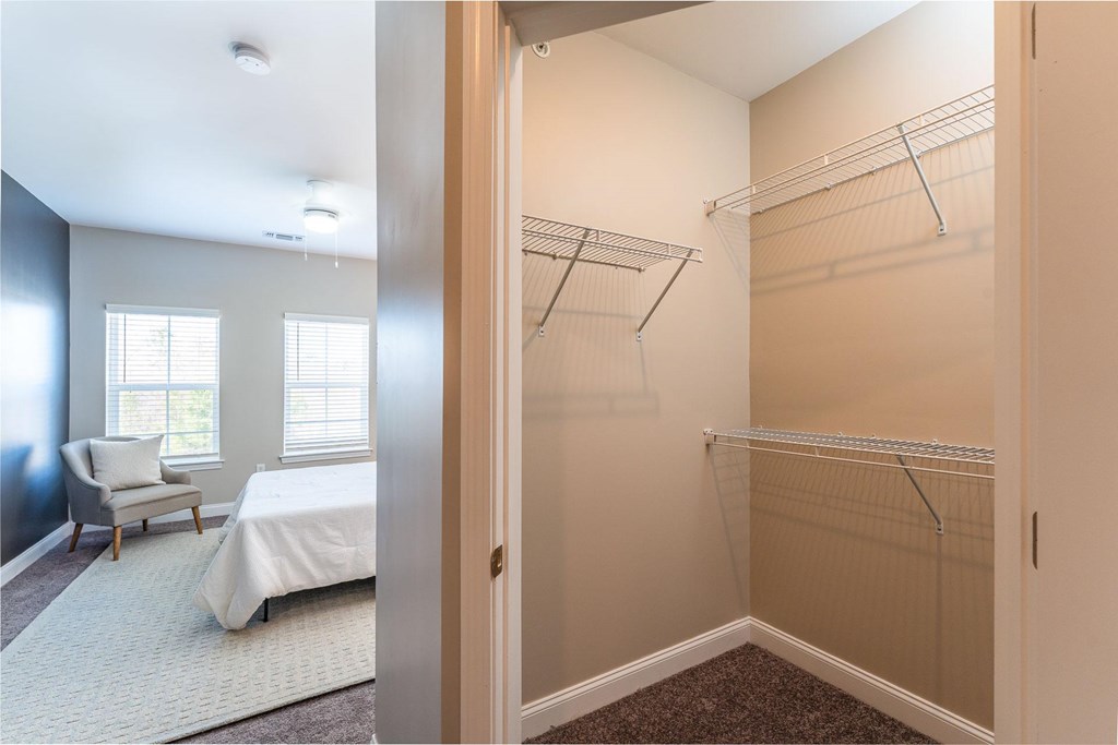 A bedroom with a bed and a walk-in closet.