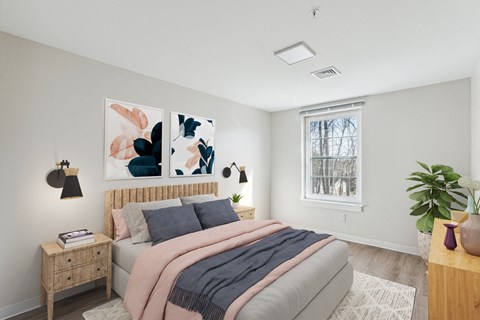 a bedroom with a bed and paintings on the wall at Shoreline Grove Apartments in Branford CT.