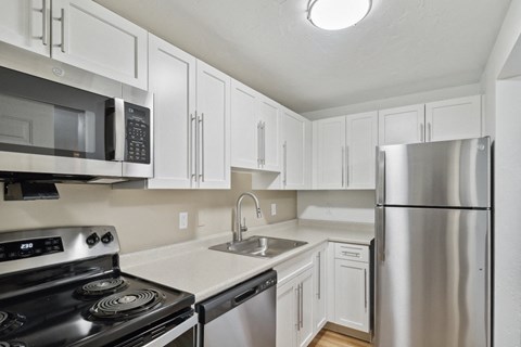 a kitchen with stainless steel appliances and white cabinets