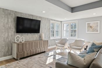 a living room with a couch and a tv on the wall at Mariner's Hill Apartments, Massachusetts