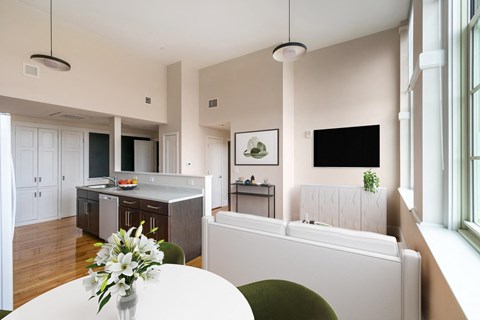 A modern kitchen with a dining table and a green chair.