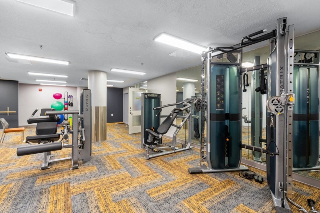 a gym with weights and cardio equipment in a building at Mill House Apartments, Greenfield, MA 01301