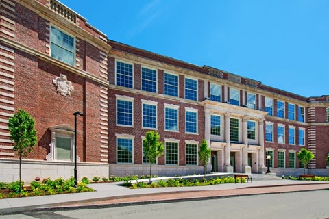 a large brick building with many windows and a street in front at Beverly Village for Living & the Arts Apartments, Beverly, 01915