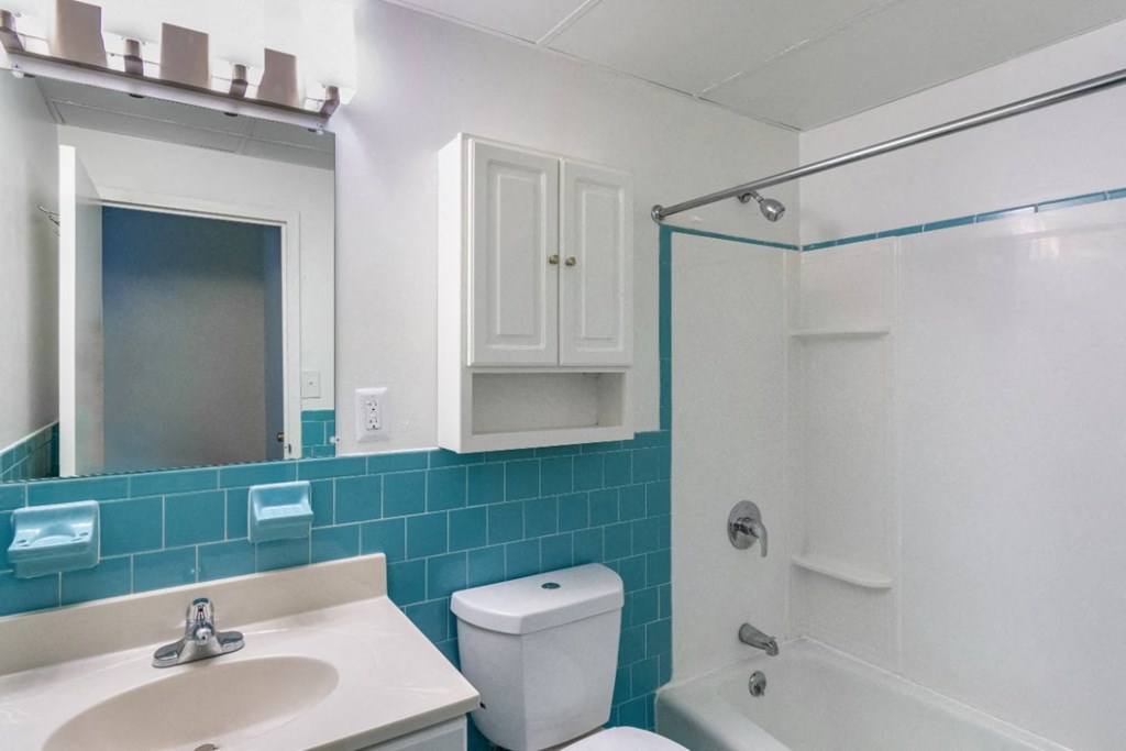 A white toilet sits next to a sink in a bathroom at Edmands House, Massachusetts, 01701