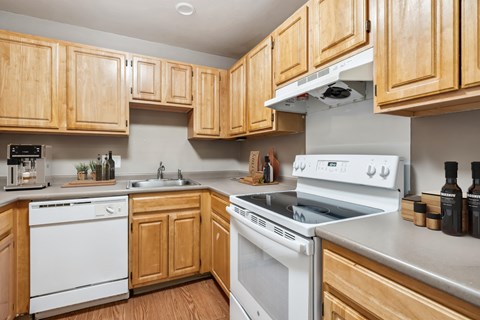a kitchen with white appliances and wooden cabinets
