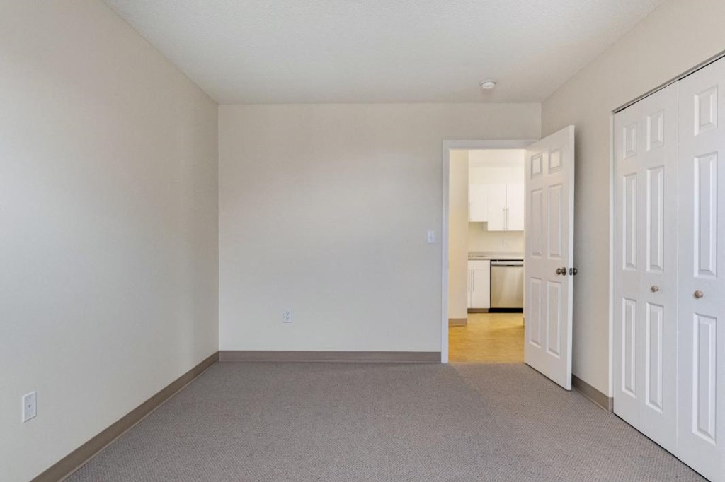 A spacious bedroom with carpeting at North Stoughton Village Apartments in Stoughton, MA