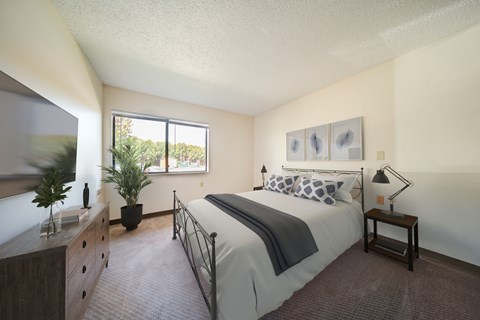 A bedroom with a large bed and a window.