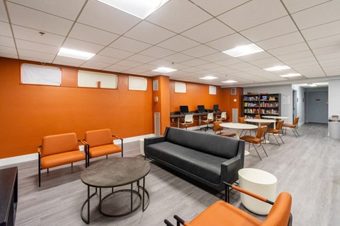 a lounge area in a library with chairs and tables at Mill House Apartments, Greenfield, MA 01301