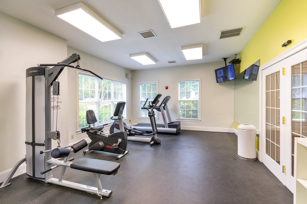 a gym with treadmills and weights and a tv at Woodlands at Abington Station, Abington