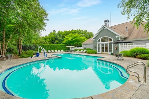 Resort style swimming pool with clubhouse at Woodlands at Abington Station Apartments, Abington, MA 2351