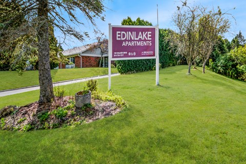 Monument sign surrounded by mature trees and lawn at Edinlake Apartments, Edinboro