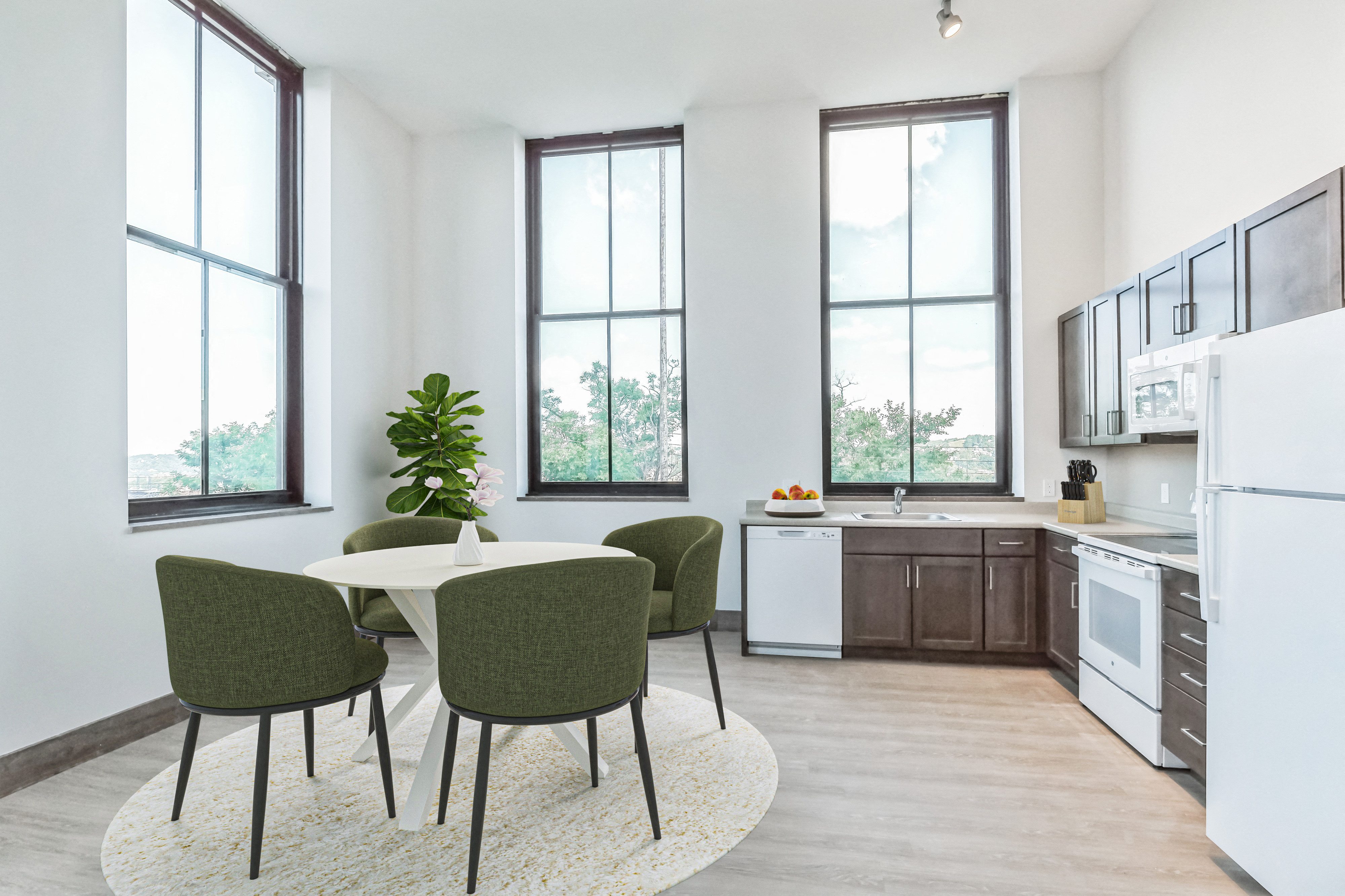 A kitchen with a table and chairs in front of a window.
