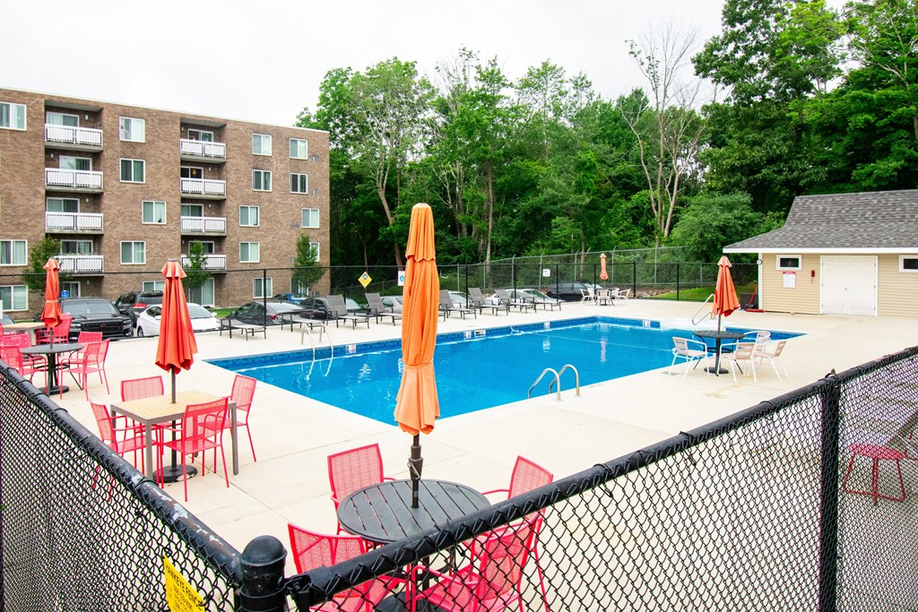 our apartments have a large pool and a patio with chairs at North Stoughton Village, Massachusetts