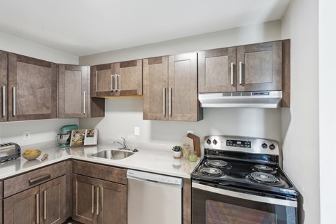 A kitchen with a stove and sink.at Rolling Green Apartments, Massachusetts