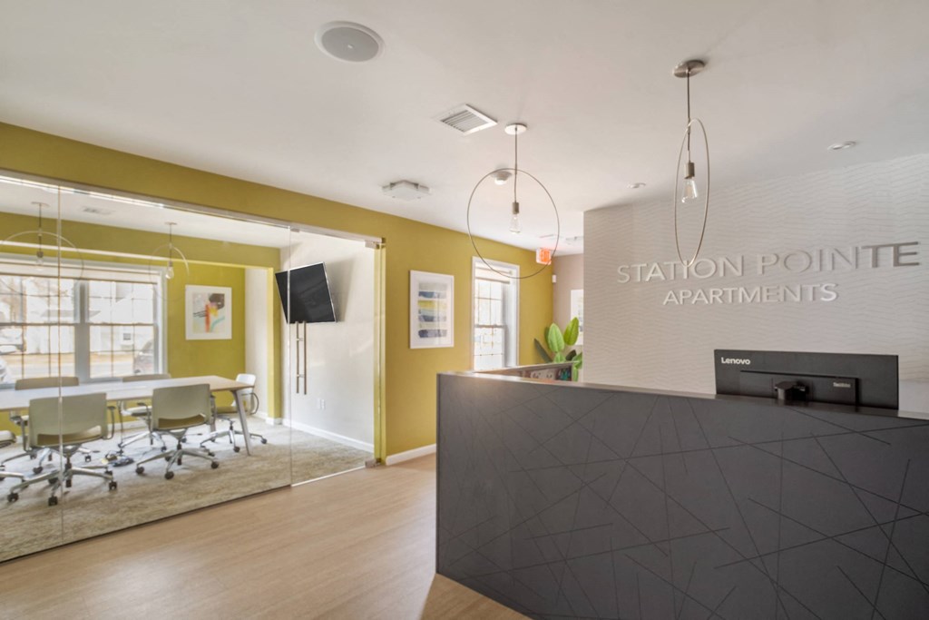 Leasing and Management Office  lobby with a reception desk and a table with chairs at Station Pointe Apartments, Mansfield, MA, 02048