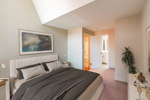 a bedroom with a bed and a painting on the wall