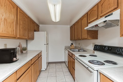 A kitchen with wooden cabinets and white appliances.