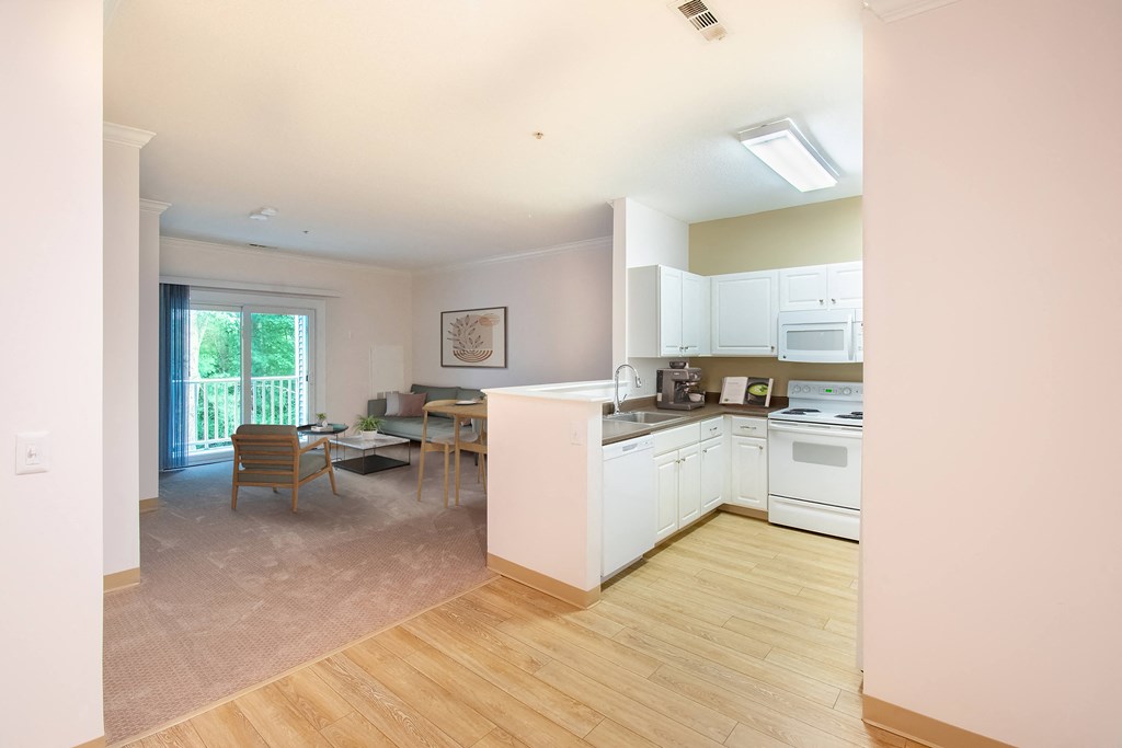 a view of a kitchen and living room with a table and chairs at Woodlands at Abington Station, Abington, MA, 02351