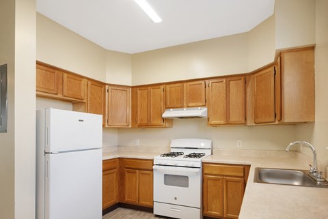 A kitchen with wooden cabinets and white appliances.