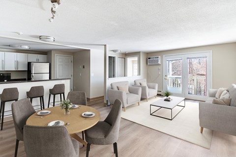A well-lit, spacious living room with a dining table set for four.