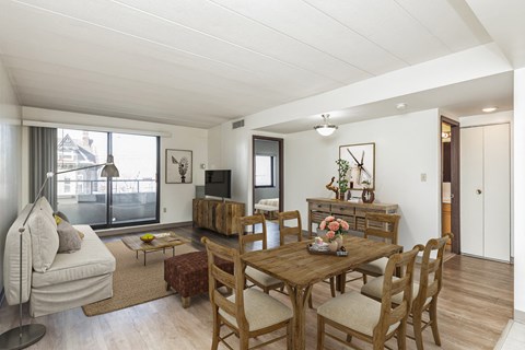a living room and dining room with a wooden table and chairs at Highland Plaza Apartments, Pittsburgh, PA.