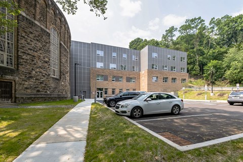 a large brick building with a parking lot in front of it at The Carina, Pittsburgh, PA