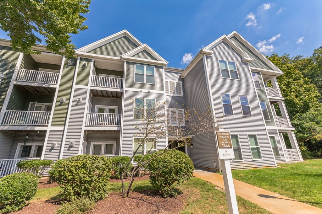 an apartment building with gray siding and green shutters at Woodlands at Abington Station, Abington
