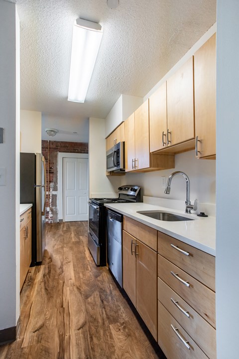 A kitchen with wooden floors and white walls at Brewery Square Apartments, Connecticut, 06513