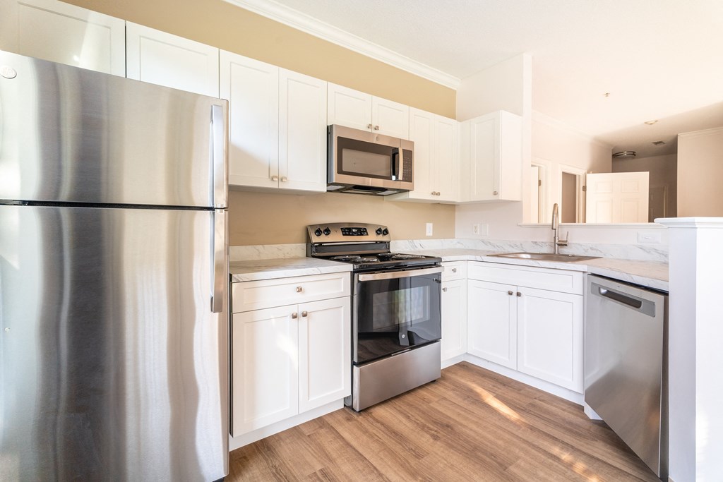 a kitchen with white cabinets and stainless steel appliances at Woodlands at Abington Station, Abington, MA, 02351