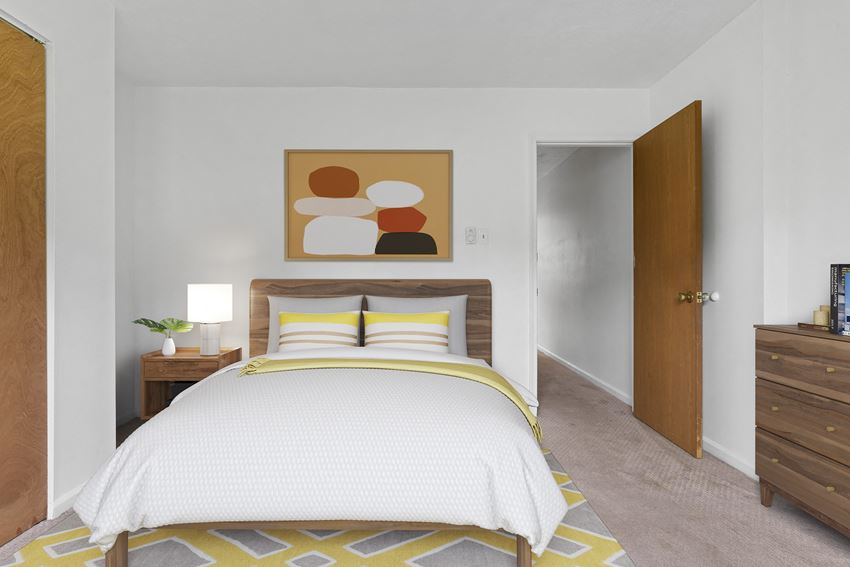 a bedroom with white walls and a yellow and white rug