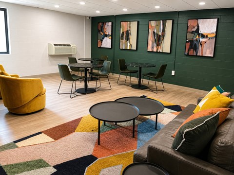A living room with a brown couch and a round table.