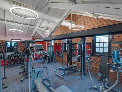 a gym with weights and cardio equipment and a brick wall at Ninth Square Apartments, Connecticut, 06510
