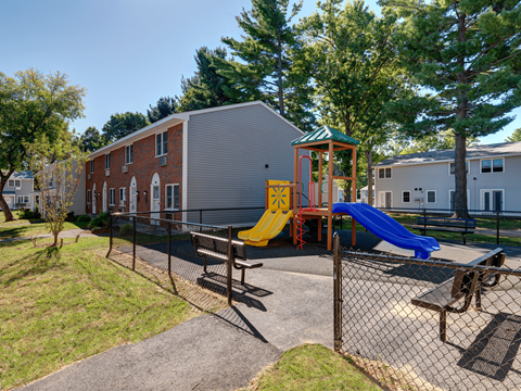 A playground with a yellow slide and a blue slide.