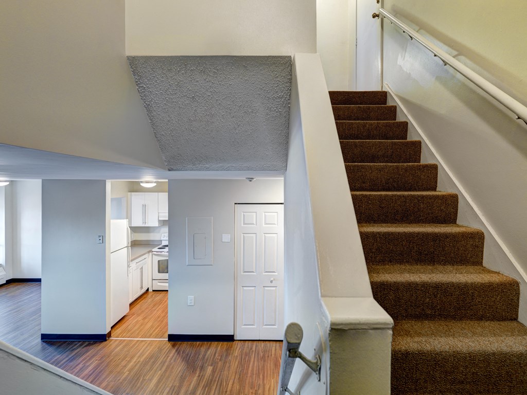 a view of a staircase in a home with a kitchen in the distance at Chapman House, E. Boston
