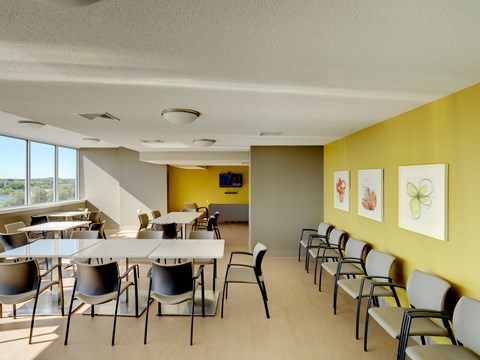a dining room with tables and chairs and yellow walls