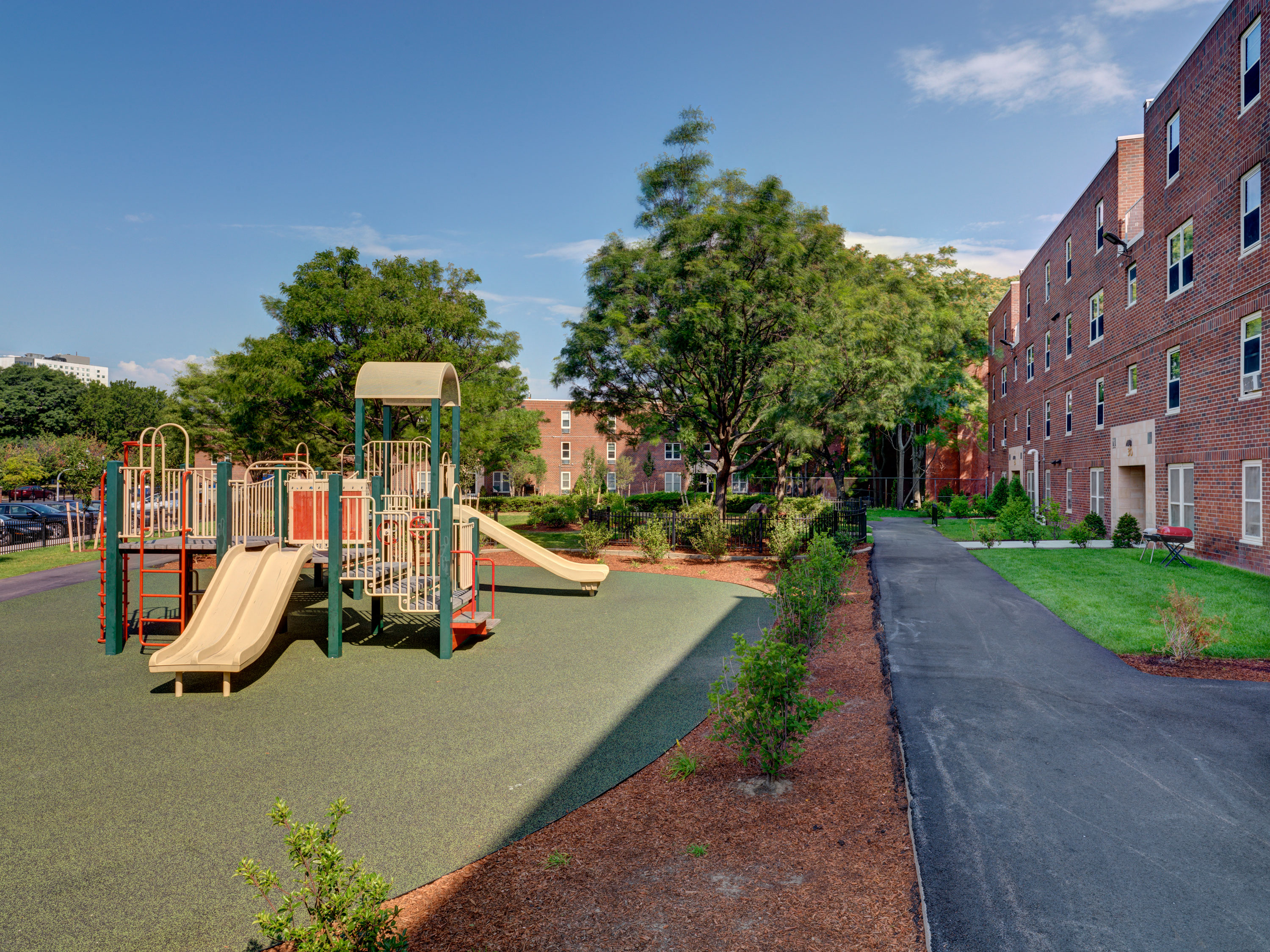 a playground with slides in front of a brick building