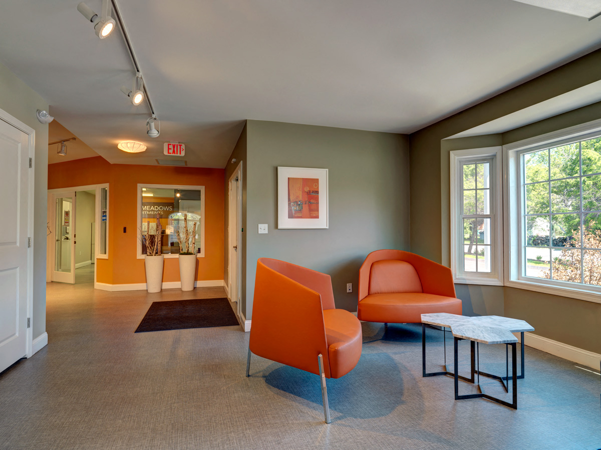 a living room with orange chairs and a table