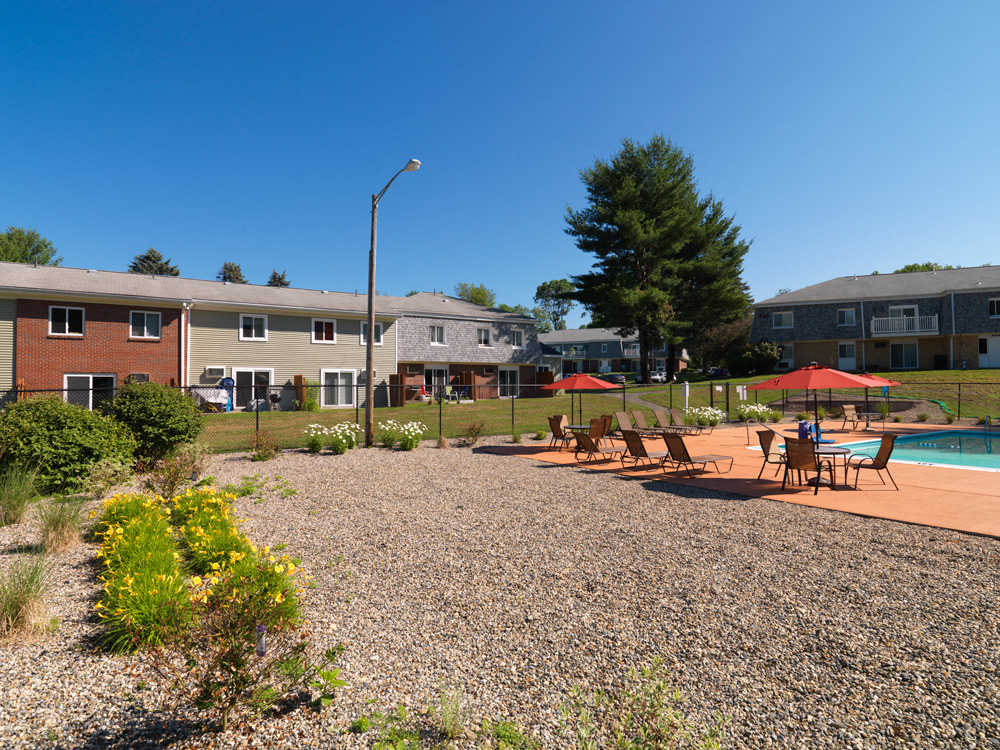 Pool with sitting area at Rolling Green Apartments in Amherst, MA