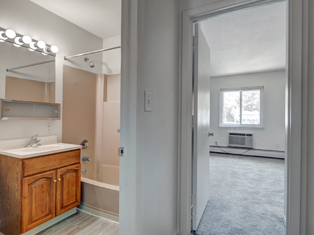 Bathroom and Carpeted Bedroom at Rolling Green Apartments in Amherst, MA.