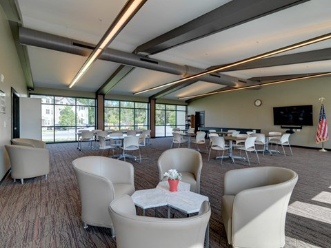 Resident Community Room with Seating, TV, Library and Large Windows at Meadows Senior Living Apartments, New Hartford