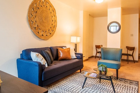 A living room with a blue couch and a wooden coffee table.