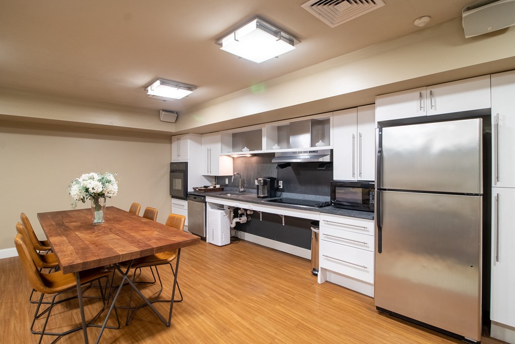 Community Room Area With Kitchen And Tables Wilber School Apartments.