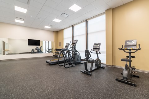 A gym with treadmills, stationary bikes, and elliptical machines.
