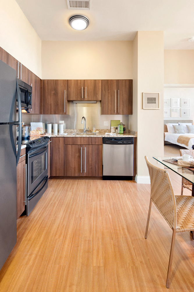 a kitchen with wooden floors and stainless steel appliances