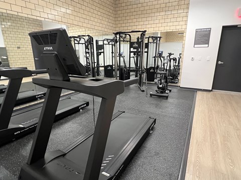 A gym with treadmills and other exercise equipment.