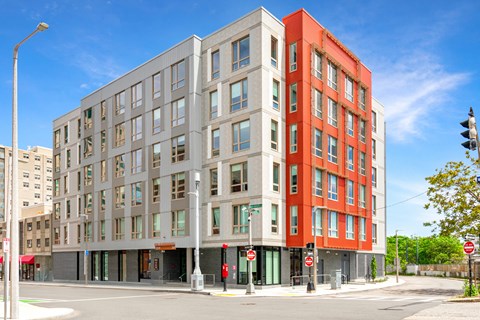 A modern multi-story building with a red and grey facade at Pok Oi Residences, Boston, MA, Massachusetts, 2111