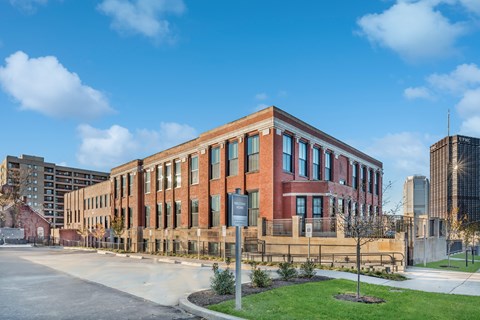 A large red brick building with a fence in front of it.