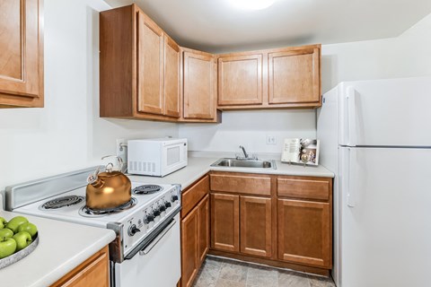 A kitchen with a white stove top oven and a white refrigerator.